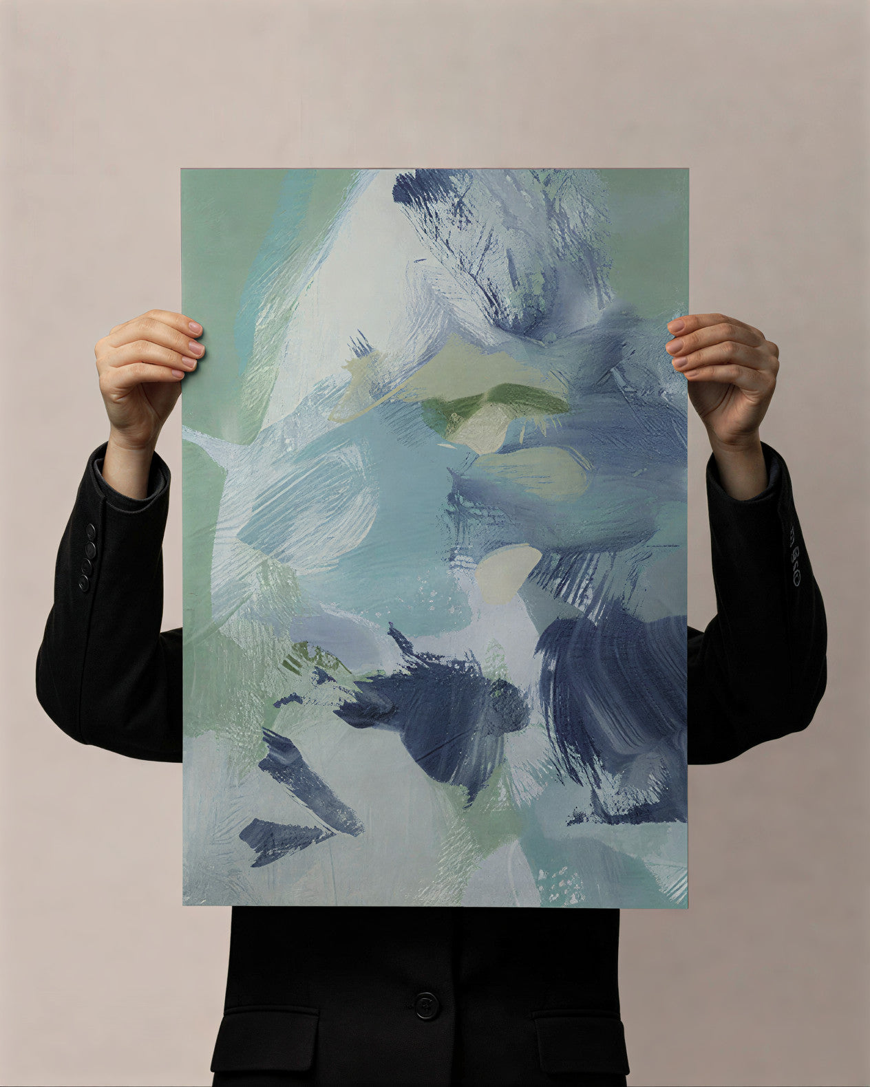 Person holding a large abstract painting with blue, green, and white colors against a beige background