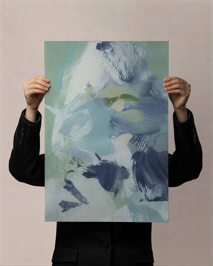 Person holding a large abstract painting with blue, green, and white colors against a beige background