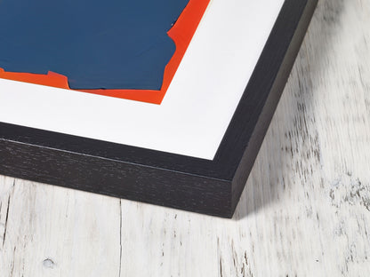 Framed abstract artwork with black frame on a textured white surface