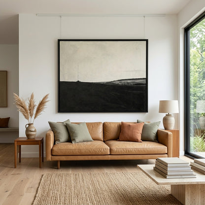 Modern living room with a brown leather sofa, framed Original contemporary landscape oil painting in black and white by Noho Art Gallery