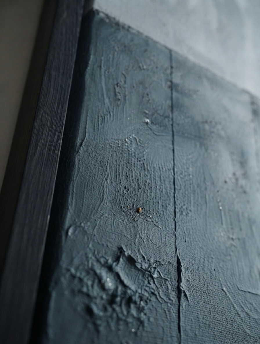 Close-up of a Large textured blue and gray abstract canvas art for luxury home decor by Noho Art Gallery, next to a dark wood frame or edge, against a softly blurred light background.