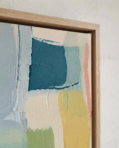 Large Sage Green and Blue Minimalist Abstract Canvas Painting by Noho Art Gallery with thick textured brushstrokes in teal, cream, yellow, green, and soft pink, set in a light natural wood frame against a white wall.