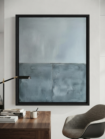Framed minimalist blue abstract canvas art with thick texture by Noho Art Gallery on a textured light gray wall above a wooden sideboard in a modern living room setting.