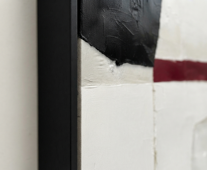 Close-up detail of a framed Minimalist black and white abstract canvas with red accent, large minimalist statement art original by Noho Art Gallery showing thick black, white, and dark red brushstrokes with a black frame.