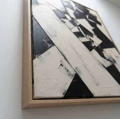 Framed Original black and white block abstract painting with contemporary minimalist design by Noho Art Gallery with thick black and off-white brushstrokes inside a light natural wood frame, photographed against a plain white wall.