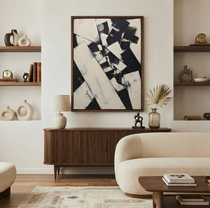 A large framed Original Black and White Abstract Painting featuring bold monochrome geometric shapes by Noho Art Gallery, above a dark wood sideboard in a styled living room with a cream boucle sofa, shelves, and decor
