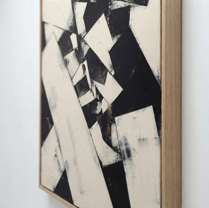Framed  Original black and white art displayed in a modern living room by Noho Art Gallery with bold black, white, and gray brushstrokes, shown hanging against a light gray wall.