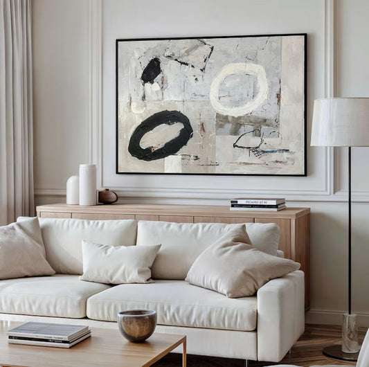 Modern living room with a white sofa, abstract art, and a lamp.
