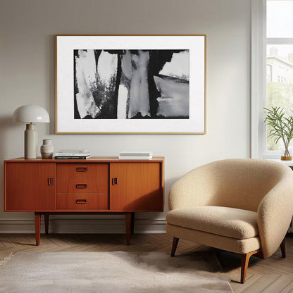 Modern living room with wooden sideboard, beige armchair, and framed artwork.