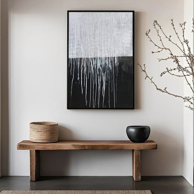 Modern interior with a wooden bench, black vase, woven basket, and abstract painting.