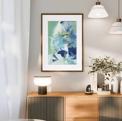 Framed abstract art on a wall above a wooden console table with decorative items.