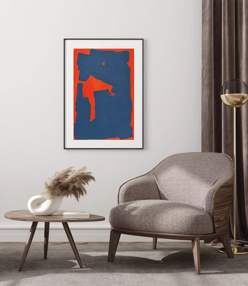 Modern living room with a gray armchair, round wooden table, and abstract art on the wall.