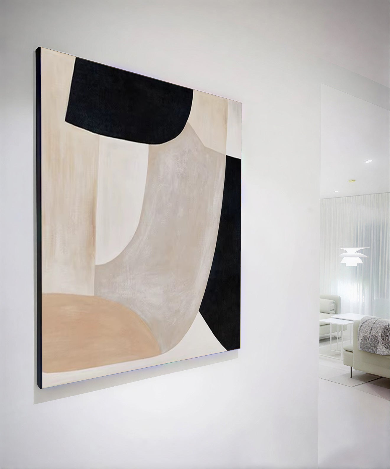 Abstract art piece with black, white, and beige colors on a white wall.