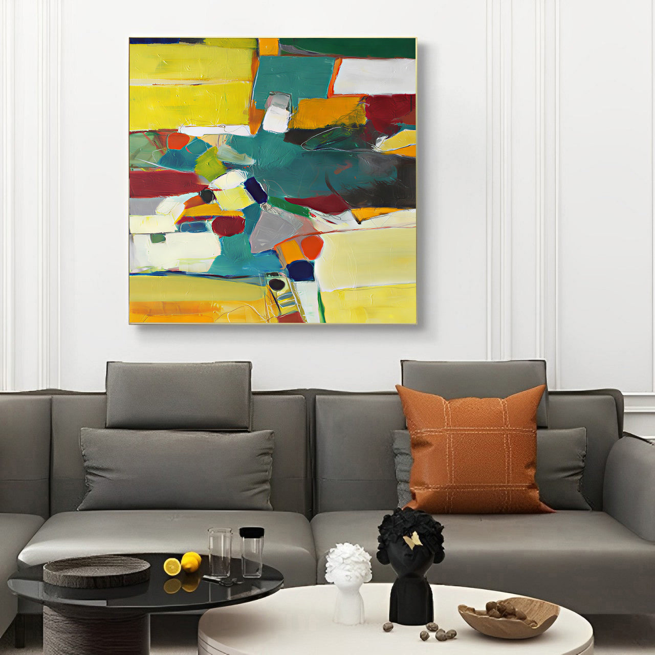 Colorful abstract painting above a gray sofa with decorative pillows.