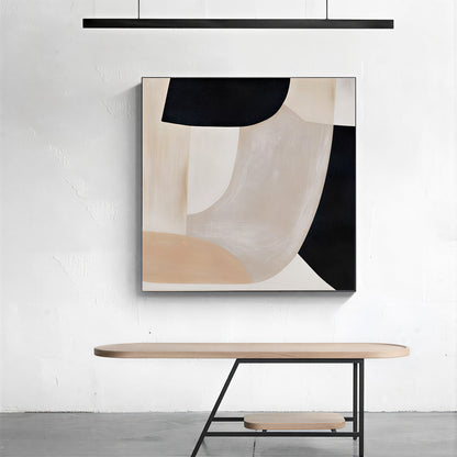 Abstract art piece on a white wall above a wooden table