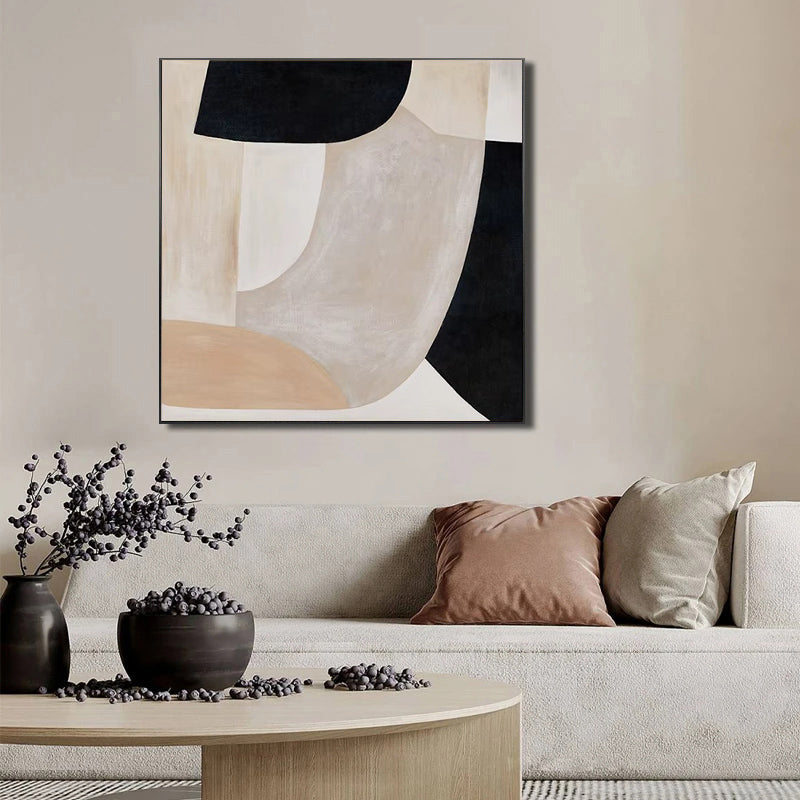 Abstract art piece on a wall above a sofa with decorative elements.