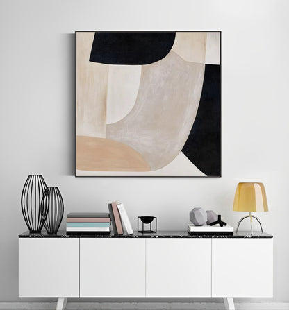 Abstract art piece on a wall above a white console table with decorative items.