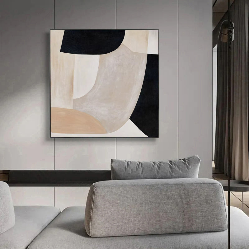 Abstract art piece on a wall above a gray sofa in a modern interior setting.