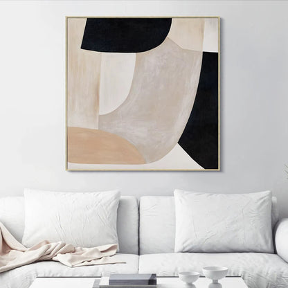 Abstract art piece on a wall above a white sofa